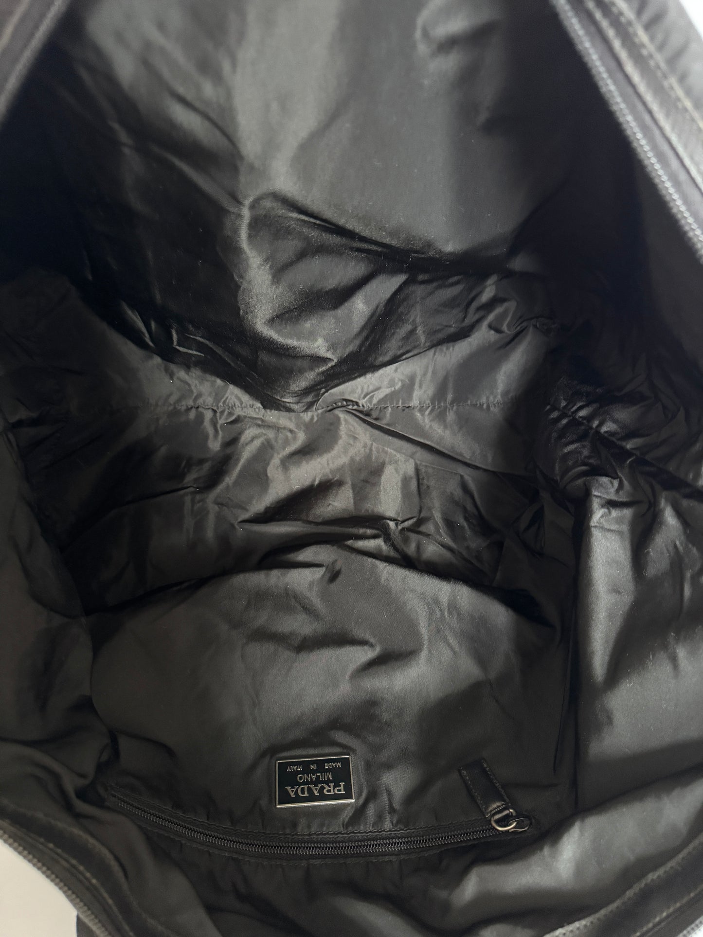 Blick ins Innere der schwarz luxury secondhand Prada Reisetasche (Reisegepäck).