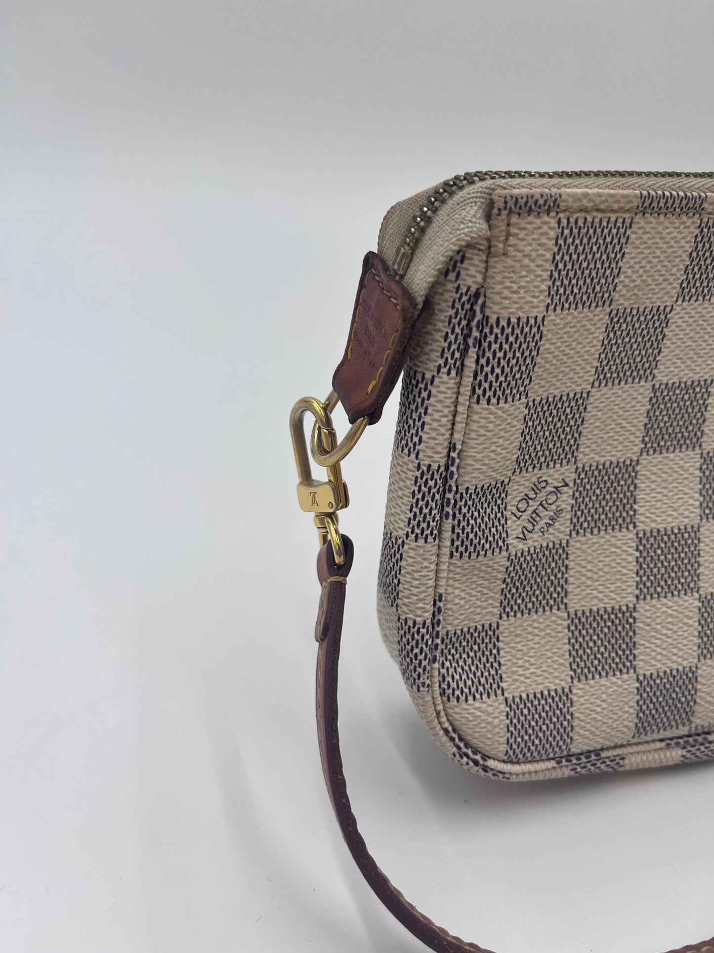 Seitenansicht der Louis Vuitton Pochette in damien d'azur – charaktervolle pre-owned Tasche.