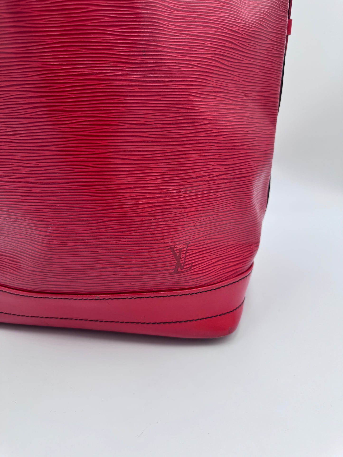 Nahaufnahme der secondhand Louis Vuitton Noe Grande – feinste Details in rot.