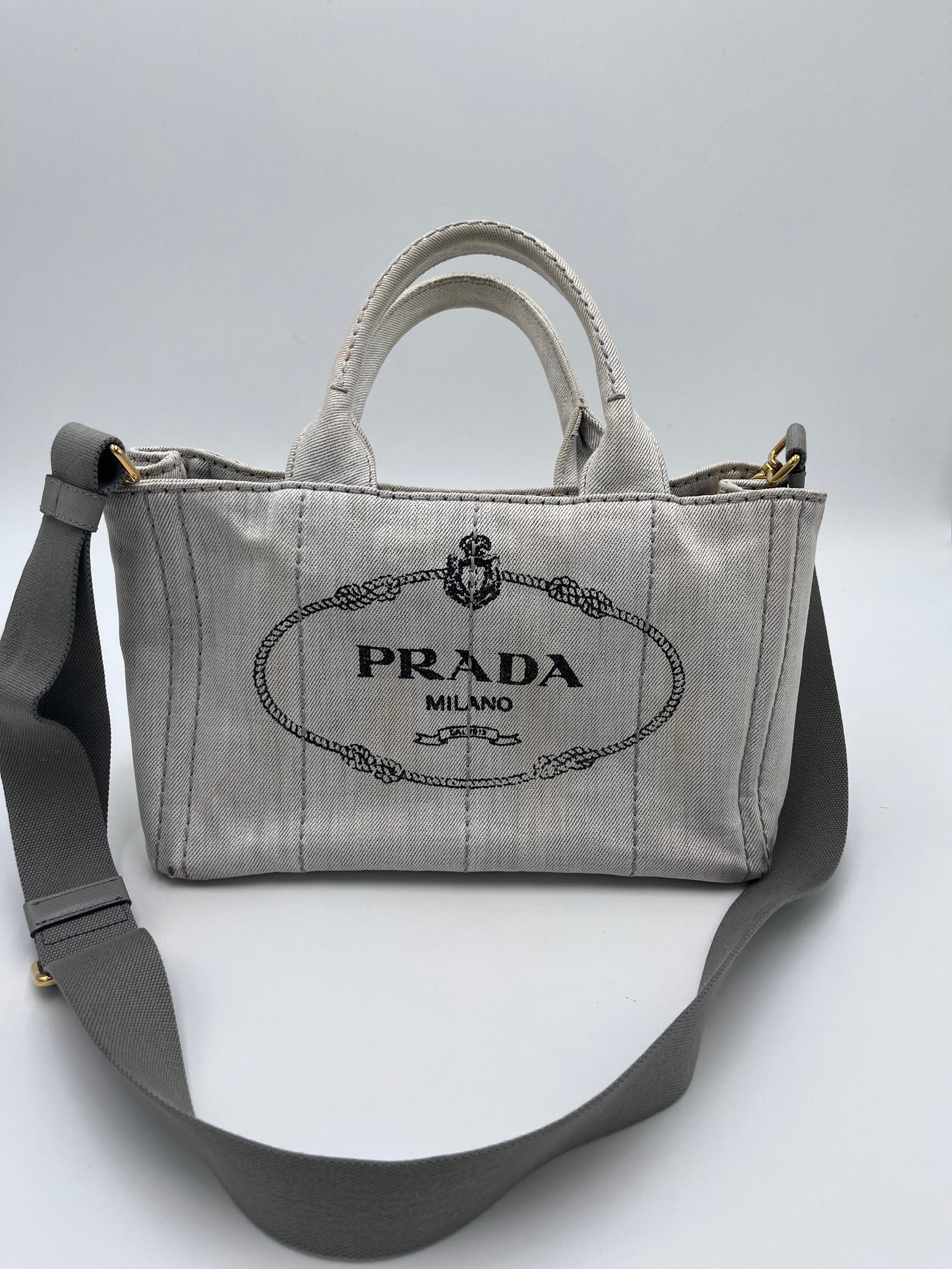 Tragegriffe dieser beige / creme Prada Canapa in Crossbody-Form.