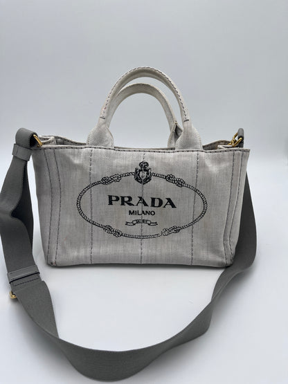 Tragegriffe dieser beige / creme Prada Canapa in Crossbody-Form.