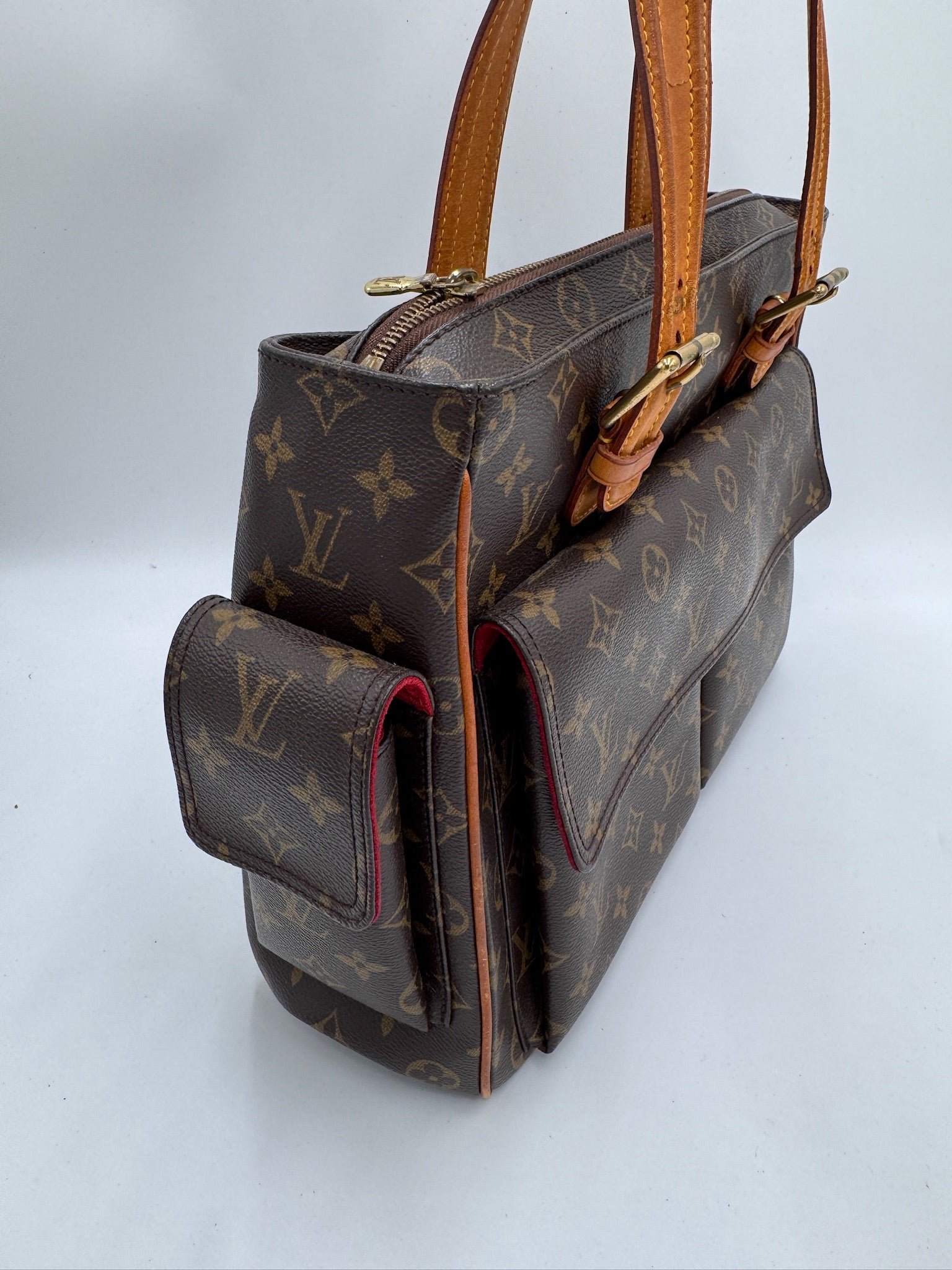 Seitliche Perspektive der pre-owned Louis Vuitton Multiplicity Cote PVC, betont das elegante Profil.