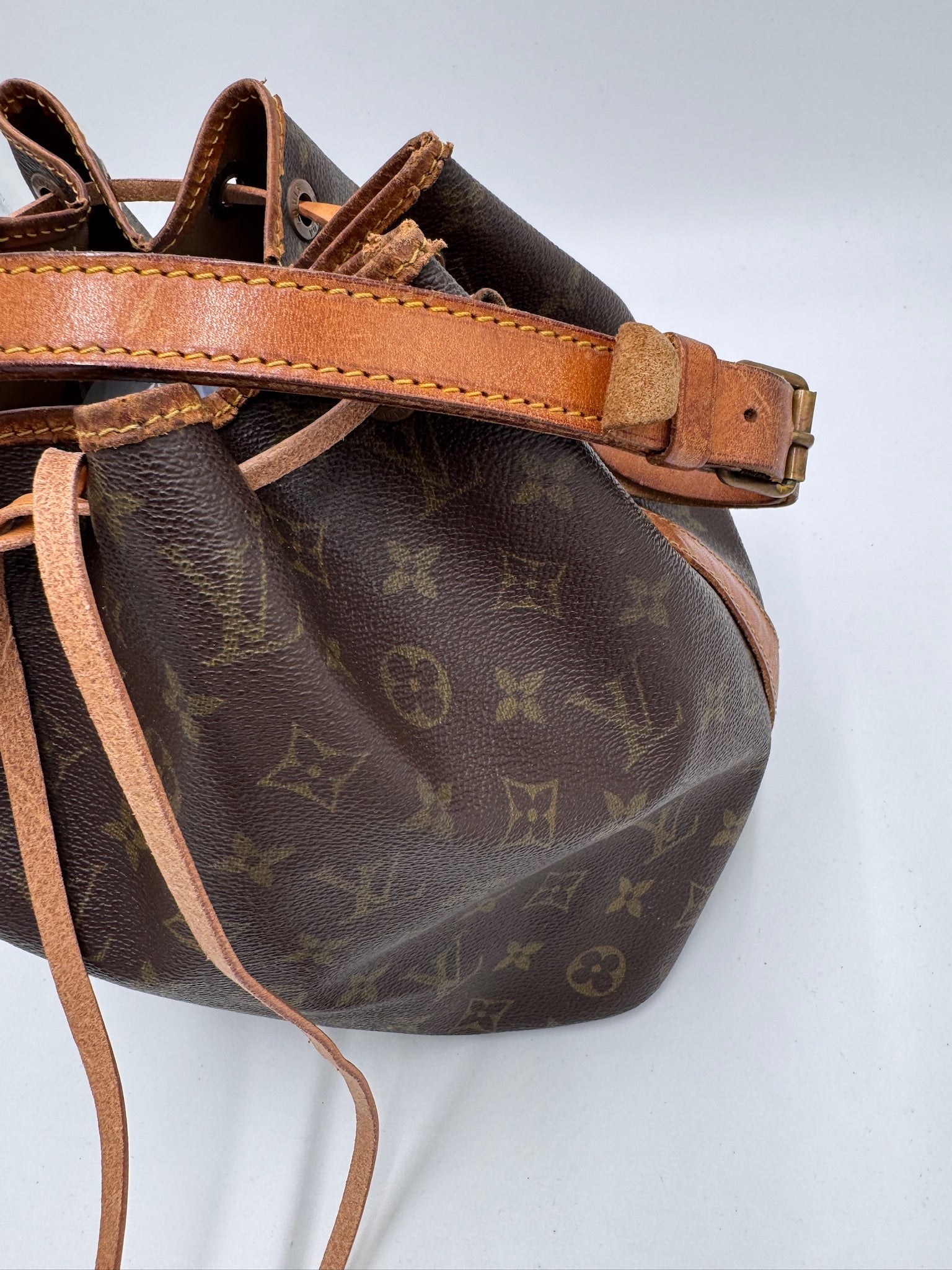 Hardware-Detailansicht der preloved Louis Vuitton Peite Noe – glänzend in Szene gesetzt.
