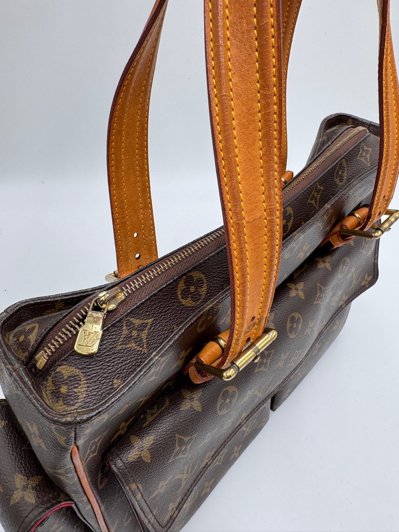 Hardware-Detailansicht der pre-owned Louis Vuitton Multiplicity Cote PVC – glänzend in Szene gesetzt.