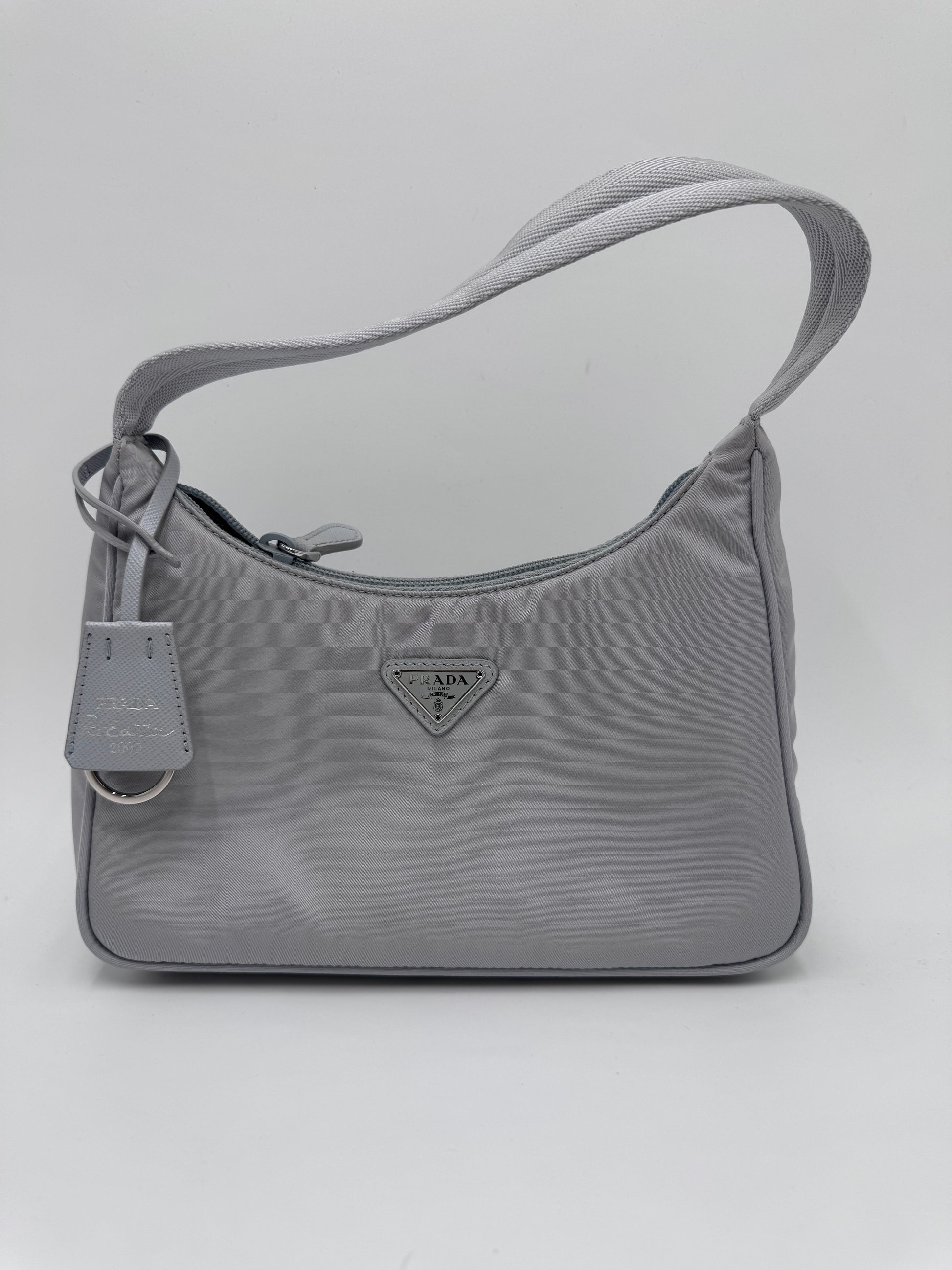 Komplette Ansicht der secondhand Prada Re-Edition 2000 – luxuriöse Pochette-Tasche in blau .