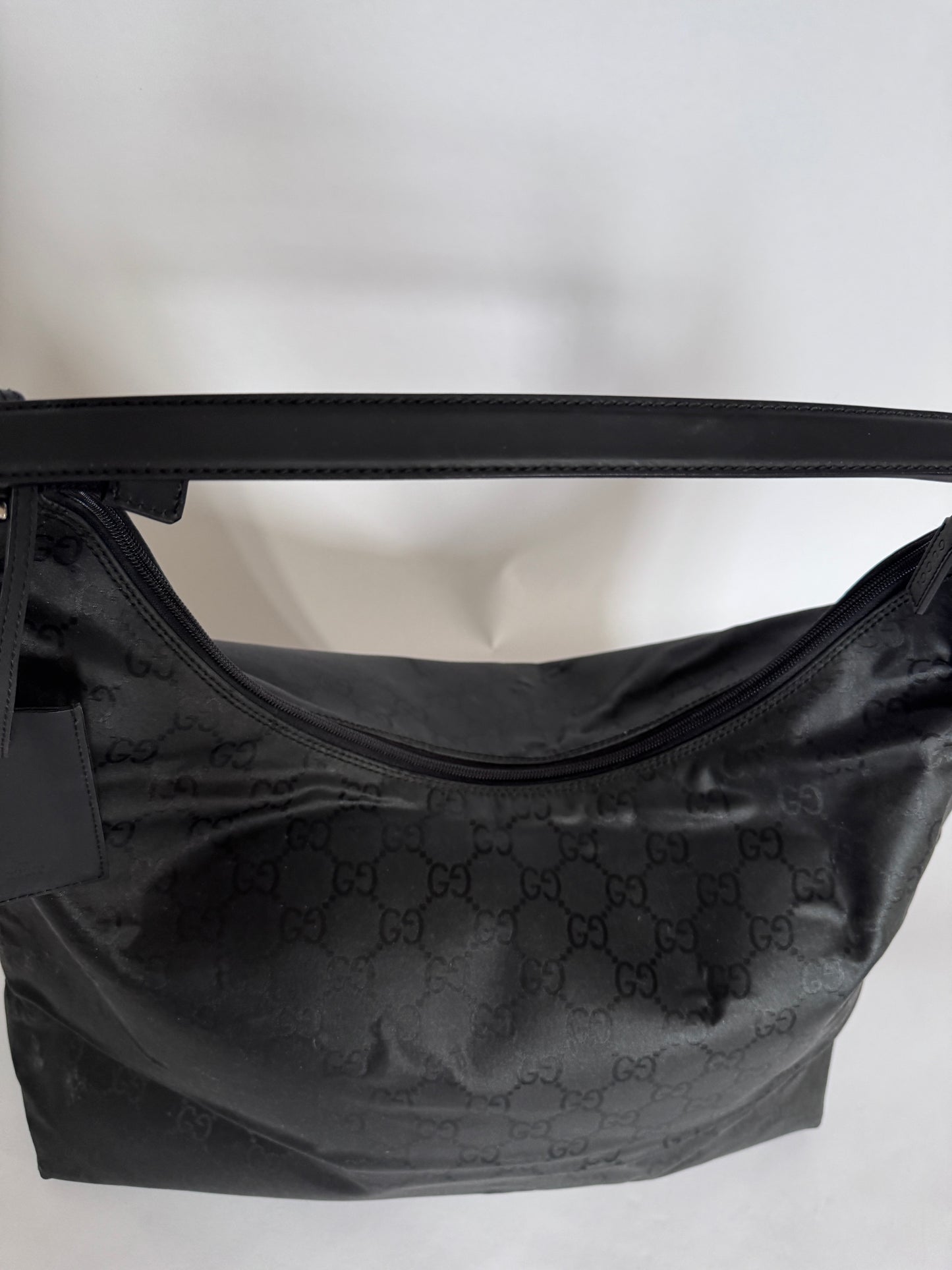 Henkel der preloved Gucci Reisetasche – schwarz, bequem und hochwertig.