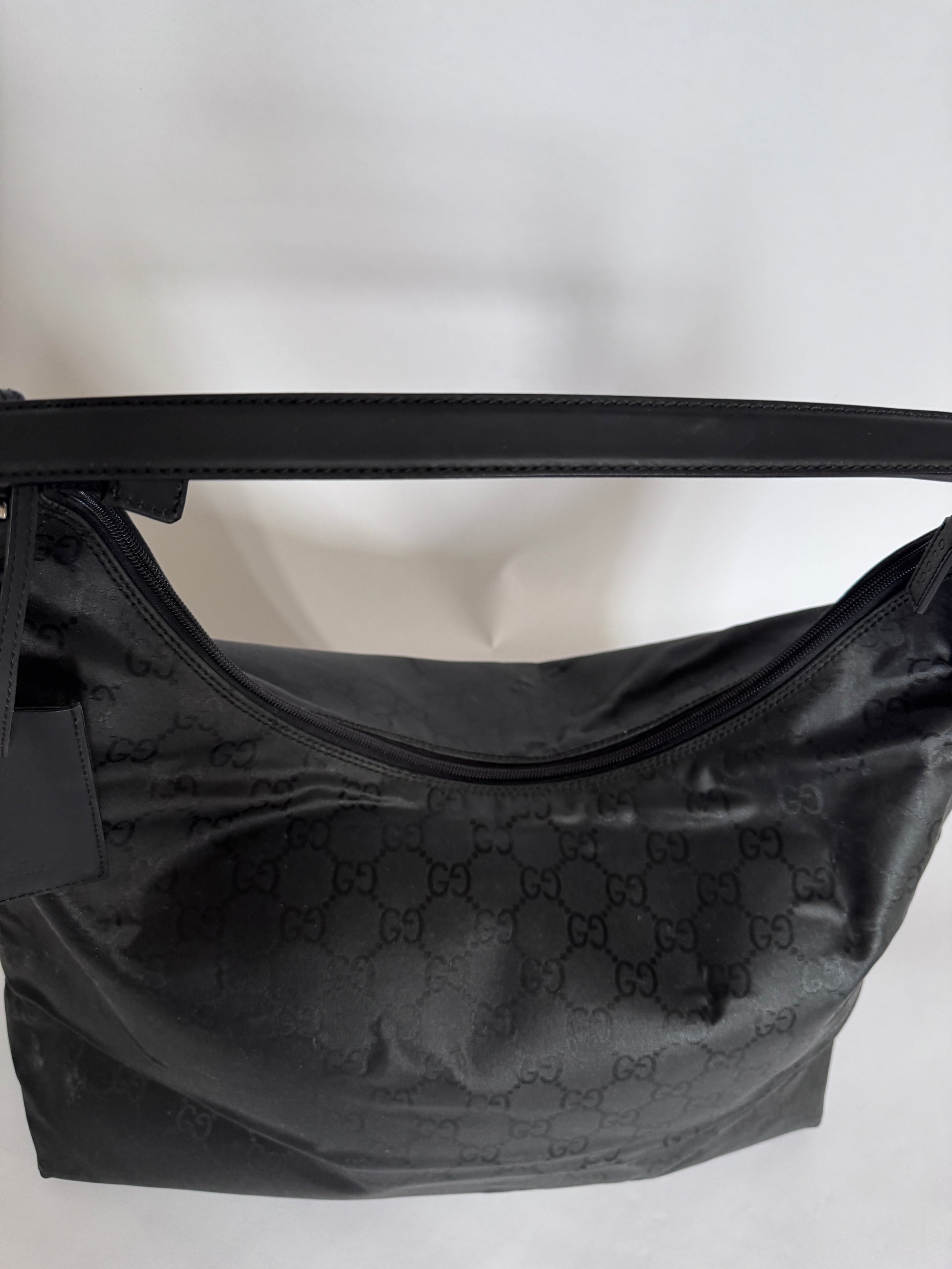 Henkel der preloved Gucci Reisetasche – schwarz, bequem und hochwertig.