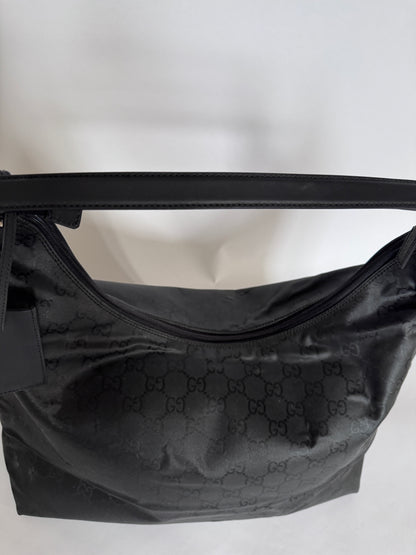 Henkel der preloved Gucci Reisetasche – schwarz, bequem und hochwertig.