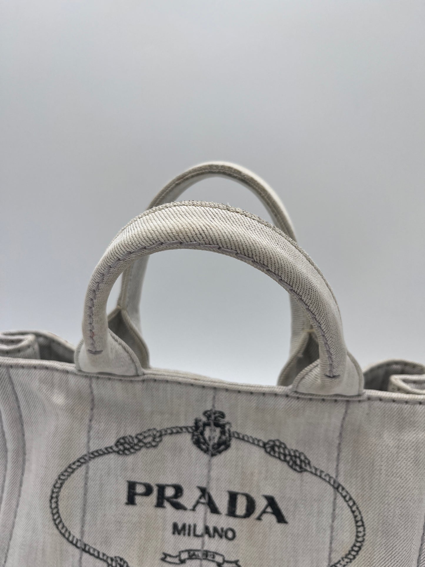 Tragegriffe dieser beige / creme Prada Canapa in Crossbody-Form.