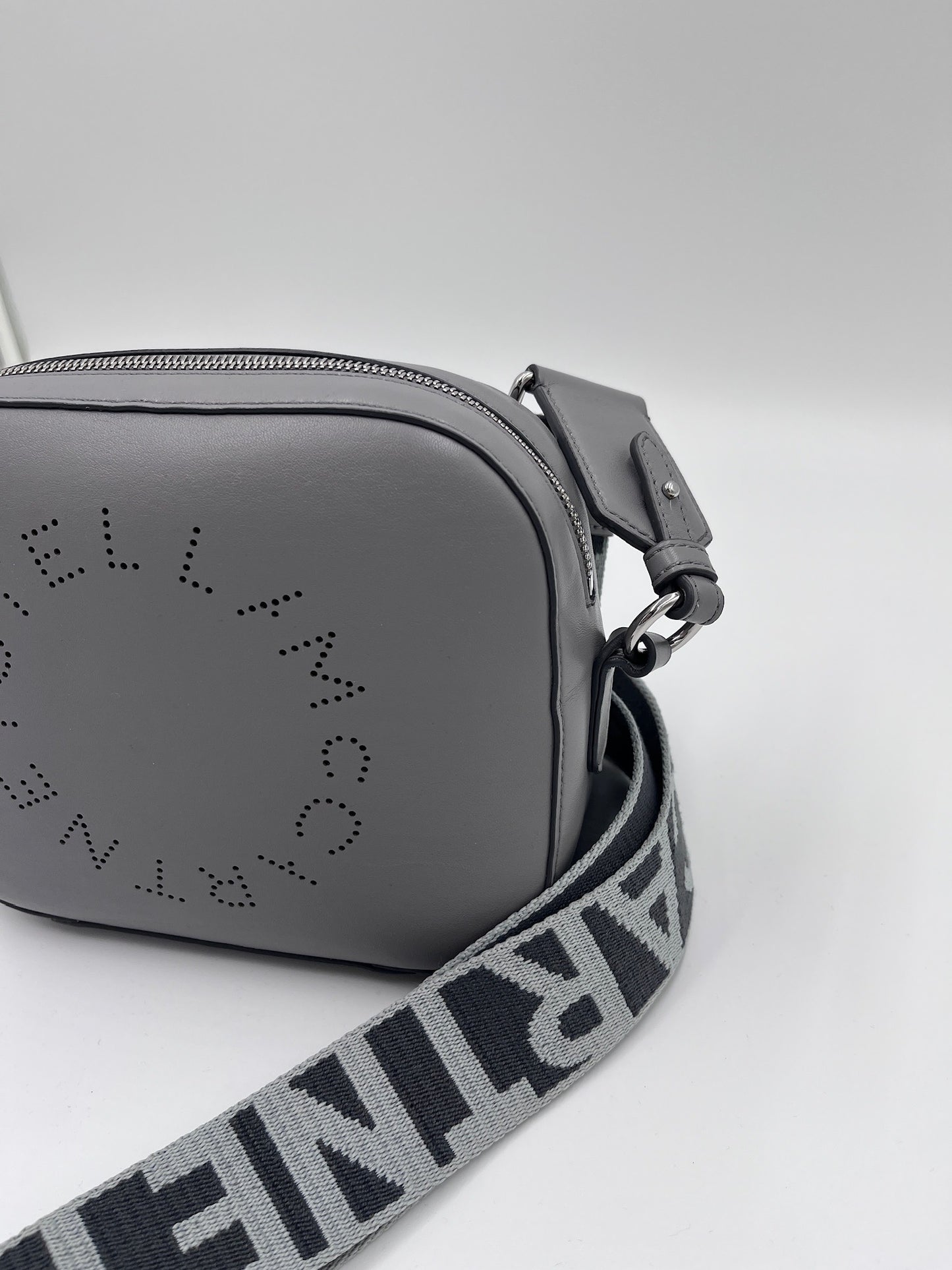 Seitenansicht der Stella McCartney crossbody in grau – charaktervolle secondhand Tasche.