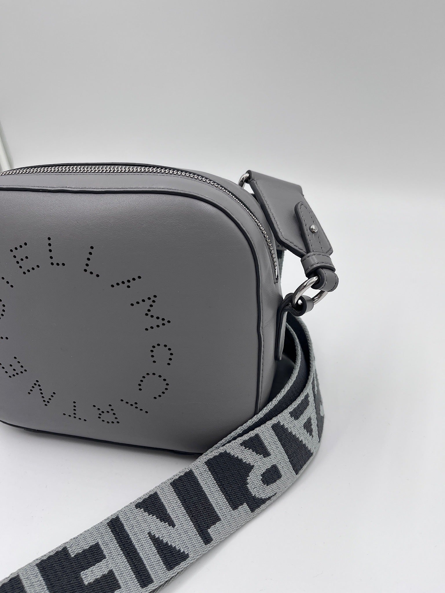 Seitenansicht der Stella McCartney crossbody in grau – charaktervolle secondhand Tasche.